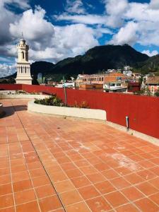 una ciudad con una pared roja y una torre de reloj en Hermoso loft en el centro histórico de Bogotá., en Bogotá