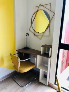 een gele stoel naast een bureau met een spiegel bij Hermoso loft en el centro histórico de Bogotá. in Bogota