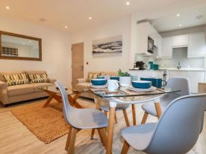 cocina y sala de estar con mesa y sillas en Quay View, en St Austell