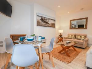 sala de estar con mesa, sillas y sofá en Quay View, en St Austell