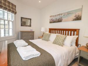 1 dormitorio con 1 cama con sábanas y almohadas blancas en Quay View, en St Austell