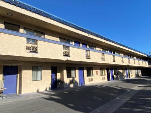 un gran edificio con puertas azules y aparcamiento en Star Inn Motel en Costa Mesa