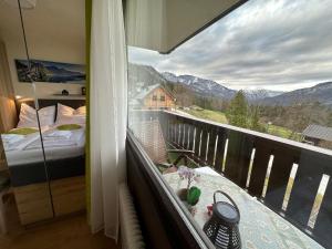 a balcony with a bed and a view of the mountains at Wohlfühlapartment Dachsteinblick in Bad Goisern