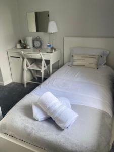 a white bed with a towel on it next to a desk at Single Room, Shared House in Bristol