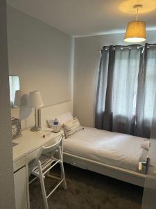 ein kleines Schlafzimmer mit einem Bett, einem Schreibtisch und einem Fenster in der Unterkunft Single Room, Shared House in Bristol