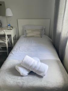 une paire de serviettes pliées assises sur un lit dans l'établissement Single Room, Shared House, à Bristol