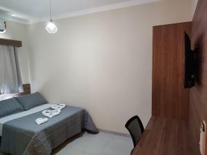 1 dormitorio con 1 cama con toallas en Hotel Vale Do Ivinhema, en Bataiporã
