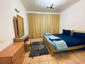 a bedroom with a blue bed and a wooden dresser at Naama bay Luxury stylish entire flat with en-suit rooms -centre of Sharm in Sharm El Sheikh +28 photos