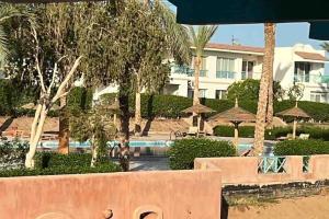 een resort met een zwembad en palmbomen en een gebouw bij Luxury & stylish Naama bay flat at the centre of Sharm in Sharm El Sheikh