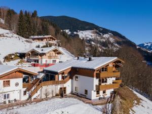 una casa en una colina cubierta de nieve con casas en Alpensteinbock Saalbach L, en Saalbach Hinterglemm