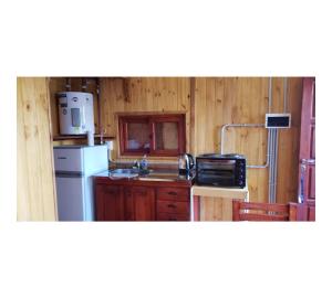 a kitchen with a white refrigerator and a sink at Hermosa Cabaña Con Pileta in Chivilcoy