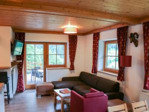 sala de estar con sofá y algunas ventanas en Alpensteinbock Saalbach L, en Saalbach Hinterglemm