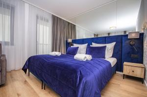 a bedroom with a blue bed with towels on it at InPoint Apartments G15 near Old Town & Kazimierz District & Optional Paid Parking in Krakow