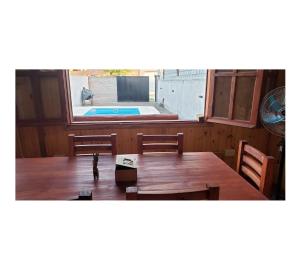 um quarto com uma mesa e cadeiras e uma piscina em Hermosa Cabaña Con Pileta em Chivilcoy