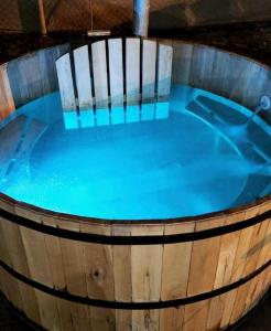 una bañera de hidromasaje llena de agua en un barril de madera en Hermosa casa con Jacuzzi y sauna en Chacras de Coria en Luján de Cuyo