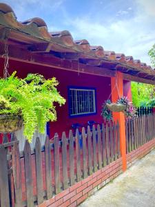 una casa roja con una valla delante en Finca el Paraíso en San Gil