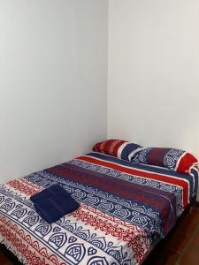 a bed with several pillows on it in a room at Finca el Paraíso in San Gil