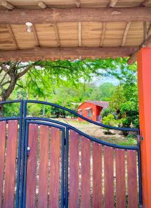 een zwarte poort met een rood huis op de achtergrond bij Finca el Paraíso in San Gil
