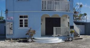 a blue house with a front door and a porch at Gloria's Hideaway in Christ Church
