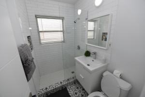 a white bathroom with a toilet and a sink at 4-PLEX in Fort Lauderdale +38 photos