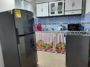 eine Küche mit einem Kühlschrank und einer Arbeitsplatte in der Unterkunft Espectacular apartamento primer piso capacidad 6 personas in Villamaría