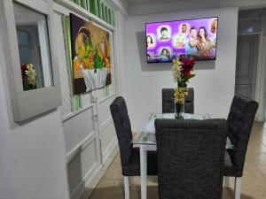 ein Esszimmer mit einem Tisch und einem TV an der Wand in der Unterkunft Espectacular apartamento primer piso capacidad 6 personas in Villamaría