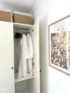 szafa z białymi ręcznikami i zdjęciem na ścianie w obiekcie Guest house on the park w mieście Burwood East