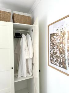 a closet with white towels and a picture on the wall at Guest house on the park in Burwood East