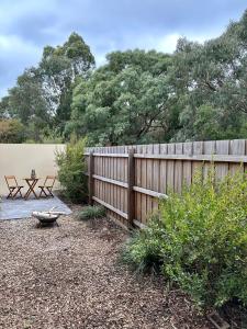 a wooden fence with a picnic table and a bench at Guest house on the park in Burwood East