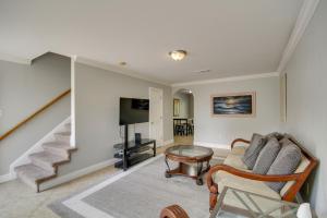 a living room with a couch and a tv and stairs at Gulfport Condo with Private Balcony - Walk to Beach! in Gulfport