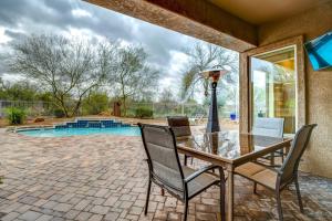 a patio with a glass table and chairs and a pool at Arizona Vacation Rental with Private Pool and Pergola! in Phoenix