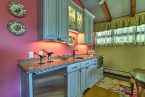 eine Küche mit rosa und grünen Wänden und einem Waschbecken in der Unterkunft Charming Blue Ridge Cottage with Stunning Views! in Spruce Pine