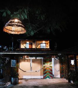 une maison avec deux portes de garage la nuit dans l'établissement Aluê Hostel, à Arraial d'Ajuda