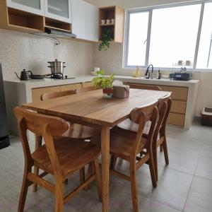 a kitchen with a wooden table and some chairs at Rumah Tropis - Lantai Dasar in Parit