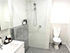 a bathroom with a shower with a toilet and a sink at Guest house on the park in Burwood East +20 photos