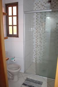 a bathroom with a toilet and a glass shower at Espaço A Corrente in Embu