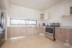 a kitchen with wooden cabinets and a stove top oven at Hispania - Dreamy Family Homes plus Communal Pool and Playground in La Paz