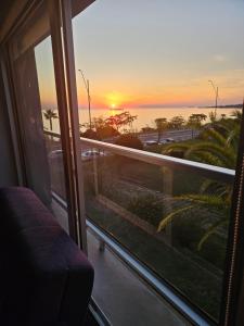 a view of a sunset from a room with a window at Rambla Sacramento - Paz frente al Río in Colonia del Sacramento