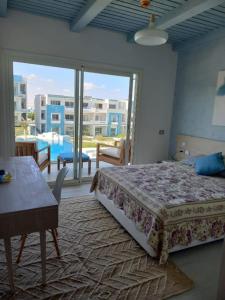 a bedroom with a bed and a view of a pool at Modern Style Serviced Apartment at Fouka Bay North Coast with Pool and Sea View in Marsa Matruh