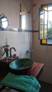 y baño con lavabo verde y ducha. en El Octógono Sagrado en Unquillo