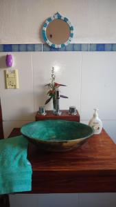 baño con lavabo verde y espejo en El Octógono Sagrado en Unquillo