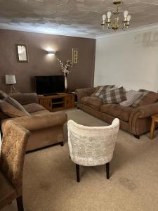 a living room with a couch and a tv at Rycroft, Kings Lynn in North Runcton