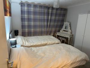 sypialnia z 2 łóżkami i biurkiem z lustrem w obiekcie Rycroft w mieście North Runcton