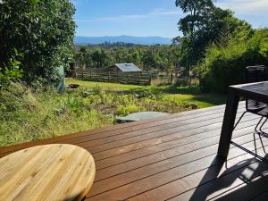 a wooden deck with a table and a view of a field at Melazzano in Lilydale