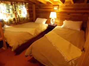 a bedroom with two beds in a log cabin at Willowbrook in Ohakune