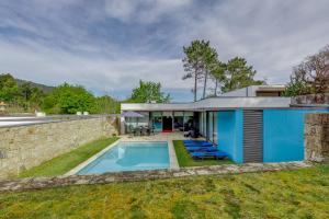 a house with a swimming pool and a stone wall at Casa do Poço in Caminha