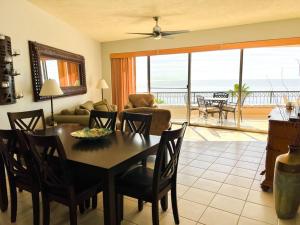 a living room with a table and chairs and a view of the ocean at Sandy Beach Sonoran Spa W504 Ocean Front Resort in Puerto Peñasco