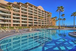a large hotel with a large swimming pool and palm trees at Sandy Beach Sonoran Spa W504 Ocean Front Resort in Puerto Peñasco