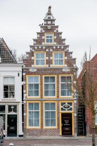 a tall brick building with a clock on it at Boutique Hotel De Eilanden in Harlingen