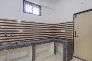a bathroom with a sink and a window at OYO Home RBS Homes in Maula Ali